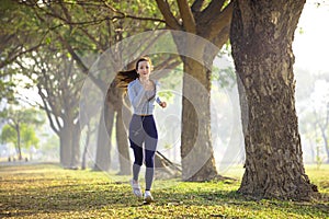 Beautiful young woman running in the park at  morning