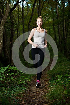 Beautiful young woman runs in forest - active runner running
