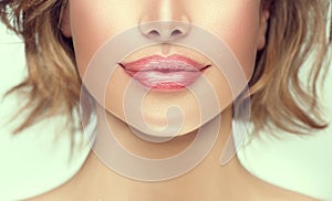 Beautiful young woman`s lips closeup. Plastic surgery, fillers, injection. Part of the model girl face, youth concept photo