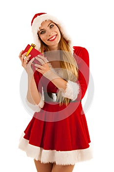 Beautiful young woman in santa claus dress hods a present isolated over white background