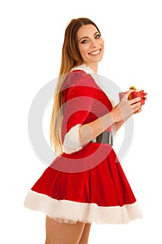 Beautiful young woman in santa claus dress hods a present isolated over white background