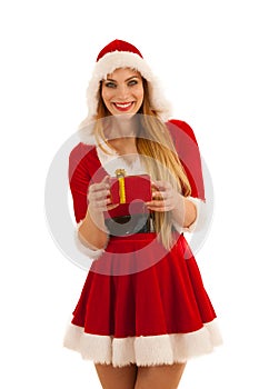 Beautiful young woman in santa claus dress hods a present isolated over white background