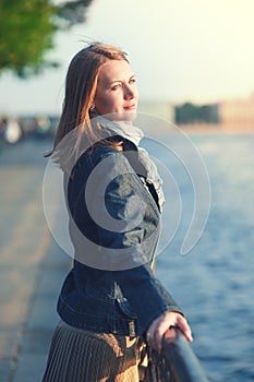 Beautiful young woman in scarf enjoy sunlight in the city