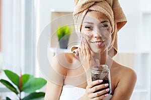 Beautiful young woman with scrub mask in spa salon