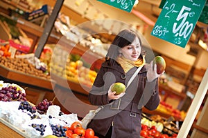 Beautiful young woman selecting mangoes