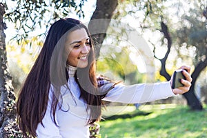 Beautiful young woman selfie in the park