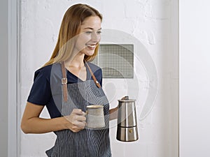 Beautiful young woman serving coffee