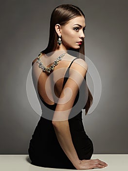 Beautiful young woman in dress and jewelry