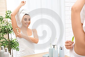 Beautiful young woman shaving armpit