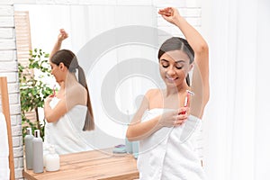 Beautiful young woman shaving armpit