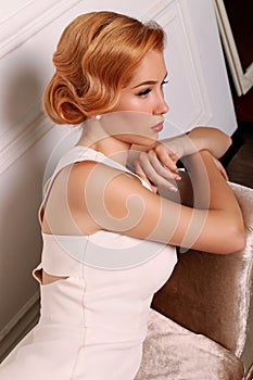 Beautiful young woman with short red hair in retro style,wears elegant white dress