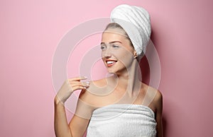 Beautiful young woman after shower on color background