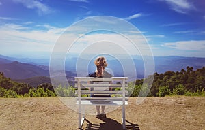 Beautiful young woman sitting on a bench at Doi Inthanon National Park