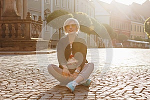 beautiful young woman sitting on cobbles on wroclaw