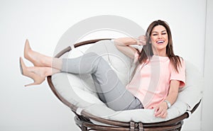Beautiful young woman sitting in comfortable chair.