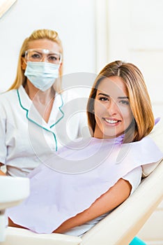 Beautiful young woman sitting in an examination chair a dentist