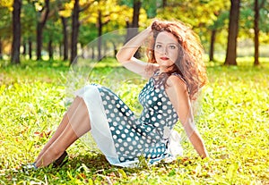 Beautiful young woman sitting on the grass