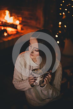 Krásny mladá žena najbližšie kozub vianočný stromček pitie kakao ibištek 