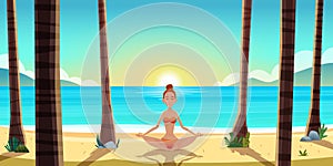 Beautiful young woman sitting on the seaside beach and relaxing in yoga pose.