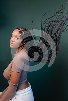 Beautiful young woman, sitting sideways, with braids of her hair flying