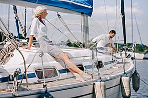 beautiful young woman sitting on yacht and looking