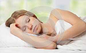 Beautiful young woman sleeping in bed