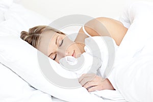 Beautiful young woman sleeping on her bed