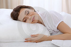 Beautiful young woman sleeping while lying in bed comfortably and blissfully. Early morning, you wake up for work or the