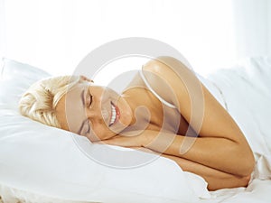 Beautiful young woman sleeping while lying in bed comfortably and blissfully. Good morning concept