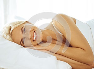 Beautiful young woman sleeping while lying in bed comfortably and blissfully. Good morning concept