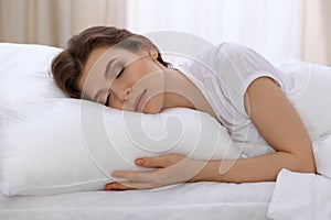 Beautiful young woman sleeping lying in bed and relaxing in the morning. A sunny day starts is the time to go for a work