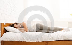 Beautiful young woman sleeping lying in her bed