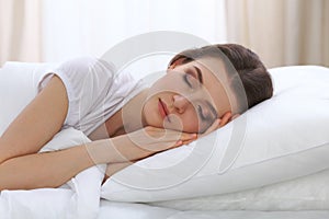 Beautiful young woman sleeping while lying in her bed and relaxing comfortably. It is easy to wake up for work or the