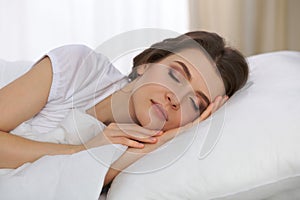 Beautiful young woman sleeping while lying in her bed and relaxing comfortably. It is easy to wake up for work or the