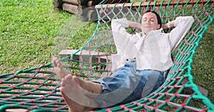 Beautiful young woman sleeping peacefully on hammock