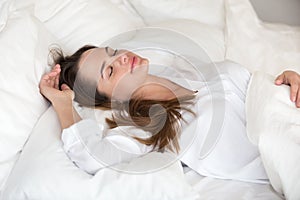 Beautiful young woman sleeping well in cozy comfortable soft bed