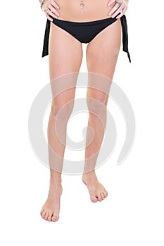 Beautiful young woman slim legs in black swimwear panties on white background