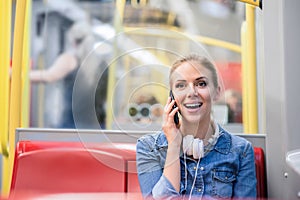 Beautiful young woman with smart phone in subway train