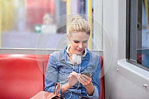 Beautiful young woman with smart phone in subway train