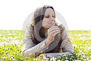 Beautiful young woman smelling flowers