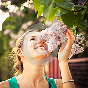 Beautiful young woman smelling jasmin flowers