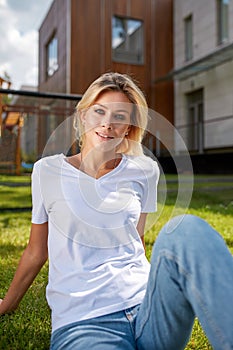 Beautiful young woman smiling at camera in a park outdoors. Outdoor recreation, happy life.