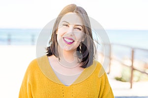 Beautiful young woman smiling cheerful walking by the sea on promenade, casual pretty girl close to the sea on sunny day