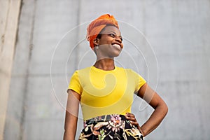 Beautiful young woman smiling in front of gray wall