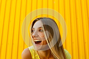 Beautiful young woman smiling lauching aloud over yellow background