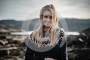 Beautiful young woman is smiling to camera with hair naturally flying around her face