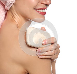 Beautiful young woman with soap bar on white background, closeup