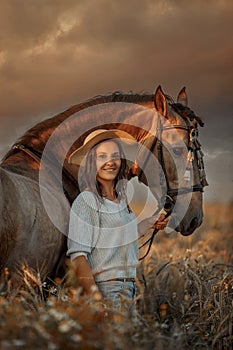 Beautiful  young woman on spanish buckskin horse in rue field