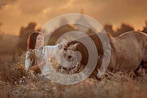 Beautiful  young woman on spanish buckskin horse in rue field