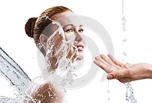 Beautiful young woman in splashes of clear water.